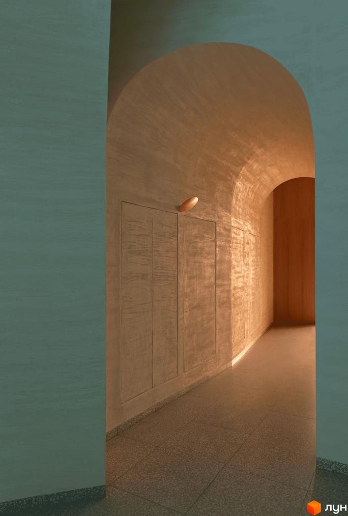 Прохід з аркою в ЖК Crystal Park Tower з текстурованими стінами та вбудованими панелями. Підлога з плитки з дрібним візерунком.