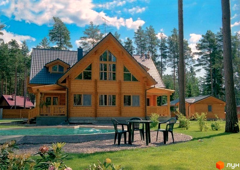 Зовнішній вигляд котеджного комплексу КМ Європейський з дерев'яними будинками та прибудинковою територією з зеленими насадженнями.