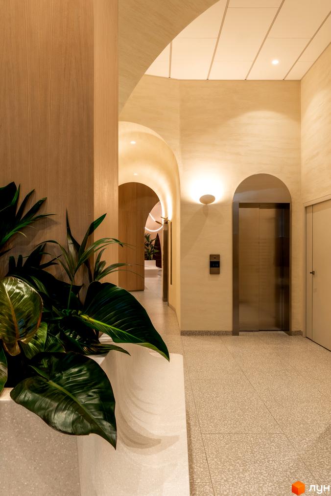 Інтер'єр житлового комплексу Crystal Park Tower з арковими проходами, ліфтом та рослинами. Сучасний дизайн та оздоблення створюють затишну атмосферу.
