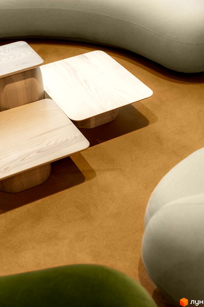 Інтер'єр житлового комплексу Crystal Park Tower з дерев'яними столиками та диваном на коричневому килимі.