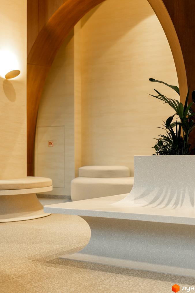 Інтер'єр ЖК Crystal Park Tower з вигнутими формами та рослиною в горщику. Дизайн приміщення виконаний у світлих тонах з акцентом на природні матеріали.