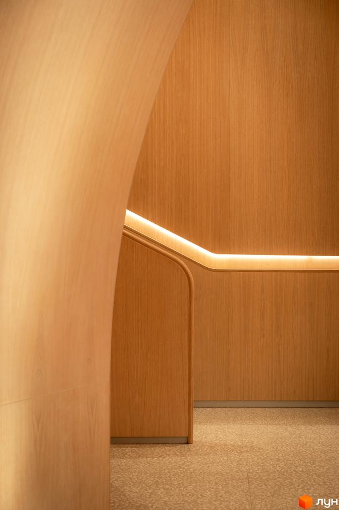 Інтер'єр ЖК Crystal Park Tower з дерев'яними панелями та підсвічуванням сходів. Сучасний дизайн та оздоблення створюють затишну атмосферу.