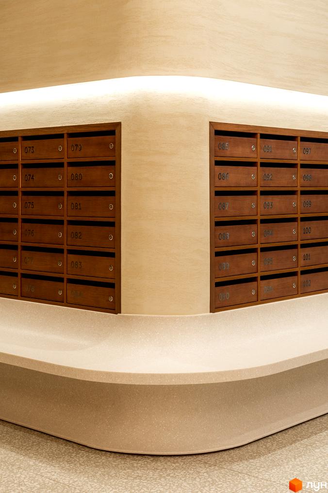 Інтер'єр ЖК Crystal Park Tower з дерев'яними поштовими скриньками та вигнутою стільницею. Сучасний дизайн та функціональність для мешканців.