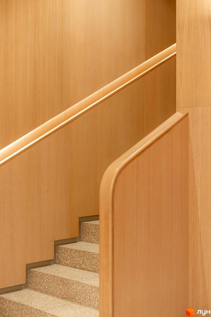 Сходи з дерев'яними стінами та підсвічуванням у житловому комплексі Crystal Park Tower. Сучасний дизайн сходів з натуральних матеріалів.