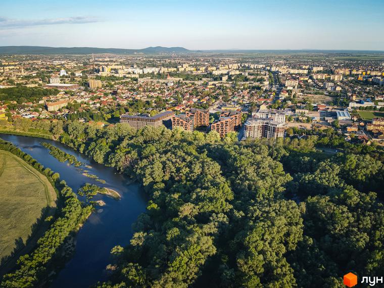 Вид на ЖК MAVERICK з висоти пташиного польоту: будинки з терасами та річка з зеленими насадженнями.