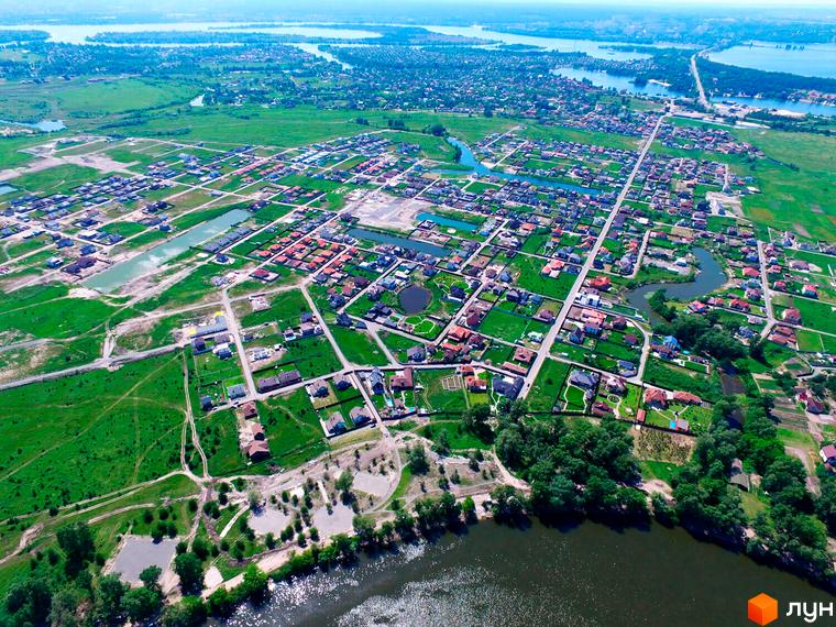 Вид на Котеджне містечко Міжріччя з висоти пташиного польоту. На фото видно будинки з червоними дахами та доглянутою прибудинковою територією.