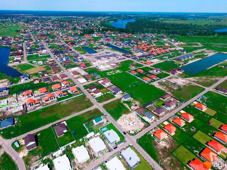 Вид на Котеджне містечко Міжріччя з висоти пташиного польоту. На фото видно будинки з помаранчевими дахами та доглянутою прибудинковою територією.