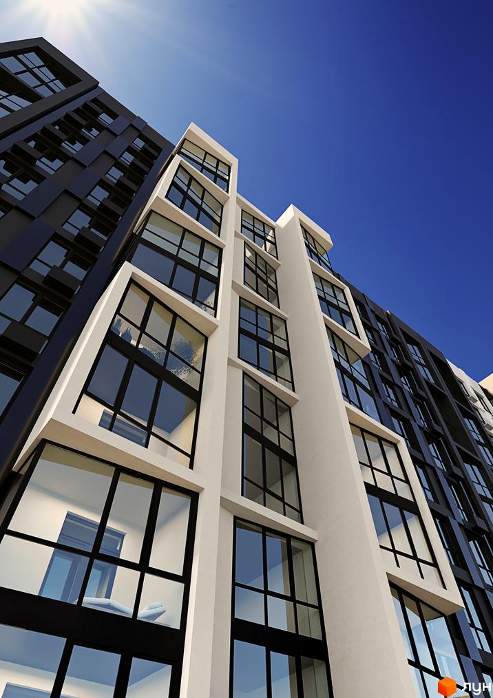 Зовнішній вигляд новобудови ЖК Аристократ з панорамними вікнами та контрастним фасадом. Будівельний проєкт височіє на фоні ясного блакитного неба.