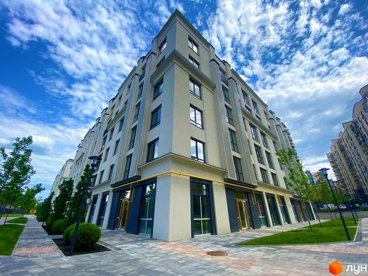 Зображення фасаду та прибудинкової території Житлового комплексу Бургундія. Багатоповерховий будинок з великими вікнами та тротуаром.