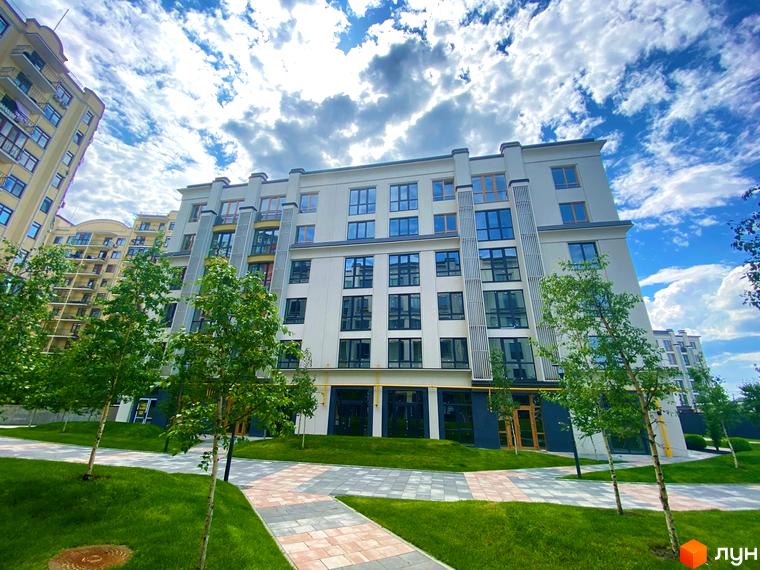 Зображення фасаду та прибудинкової території Житлового комплексу Бургундія. Навколо будинку зелені насадження та пішохідні доріжки.