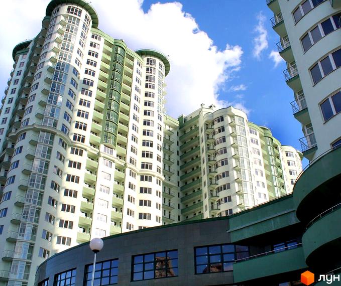 Житловий комплекс Смарагдовий: світло-зелені багатоповерхові будинки з округлими фасадами та балконами. Внизу видно частину будівлі з великими вікнами.