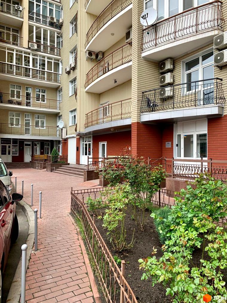 Житловий комплекс вул. Антоновича, 72 з балконами та прибудинковою територією з зеленими насадженнями та пішохідними доріжками.