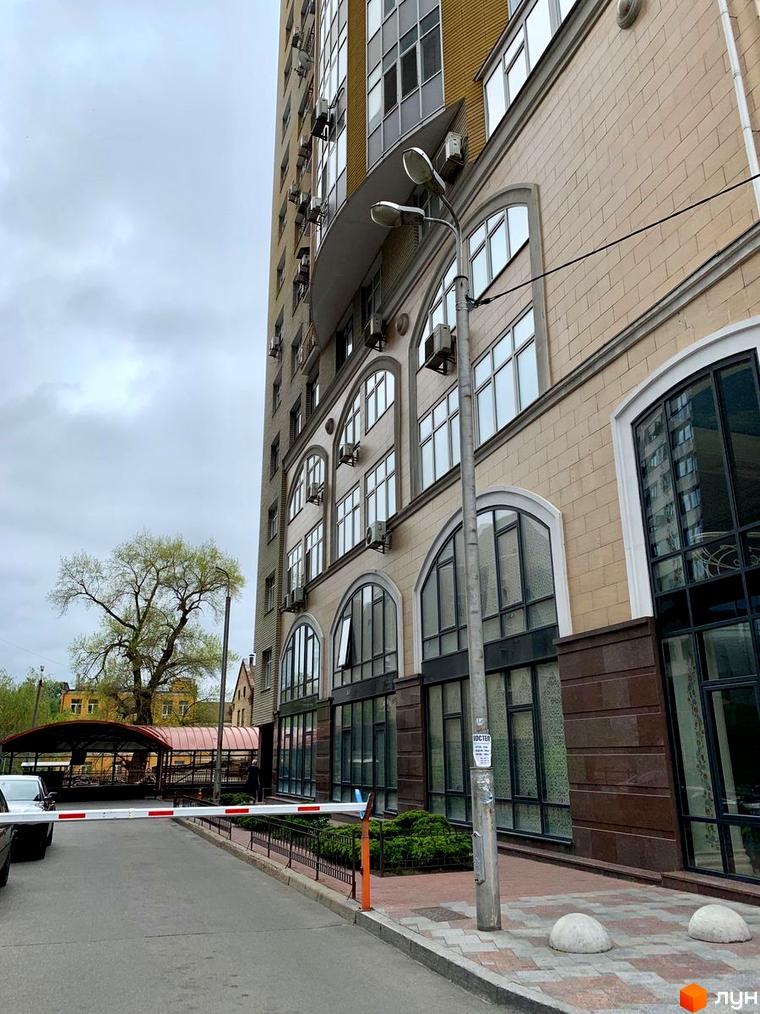 Житловий комплекс на вул. Антоновича, 72 з сучасним фасадом та прибудинковою територією, облаштованою зеленими насадженнями.