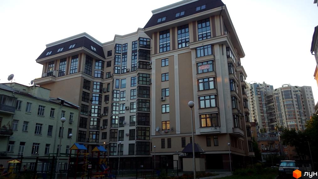 Житловий комплекс Botanic Paradise: багатоповерховий будинок зі світлим фасадом, великими вікнами та дитячим майданчиком на прибудинковій території.