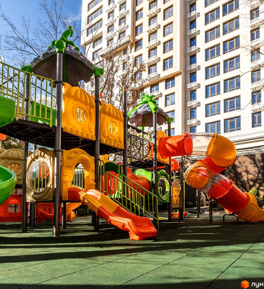 Зовнішній вигляд житлового комплексу Тридцять восьма перлина з ігровим майданчиком на прибудинковій території.