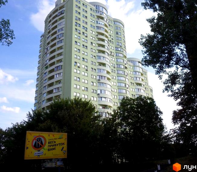 Житловий комплекс на просп. Науки, 80а/73, висотна будівля з балконами та зеленими насадженнями на прибудинковій території.