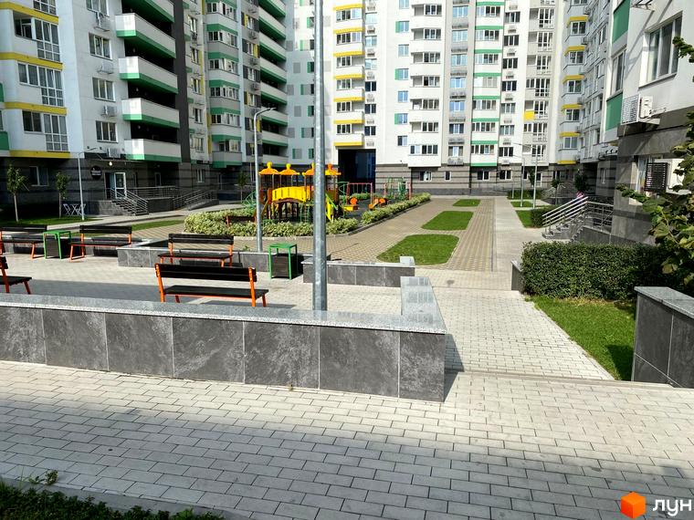 Житловий комплекс Харківський: фасади будинків та доглянута прибудинкова територія з дитячим майданчиком та зонами відпочинку.