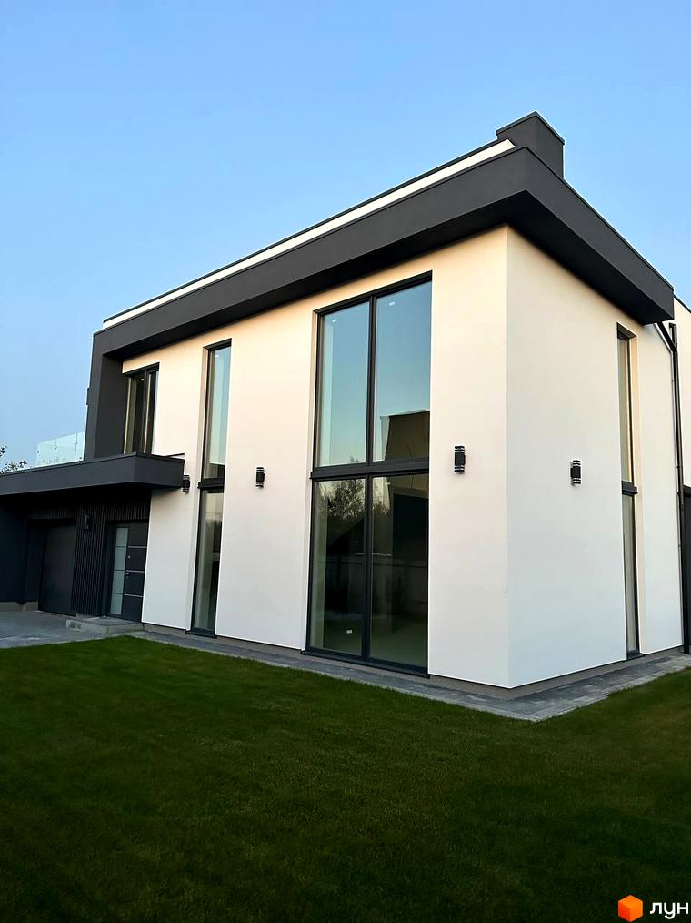 Котеджне містечко КМ PARK by berezivka: двоповерхова новобудова з білими стінами та великими вікнами, оточена зеленою галявиною.