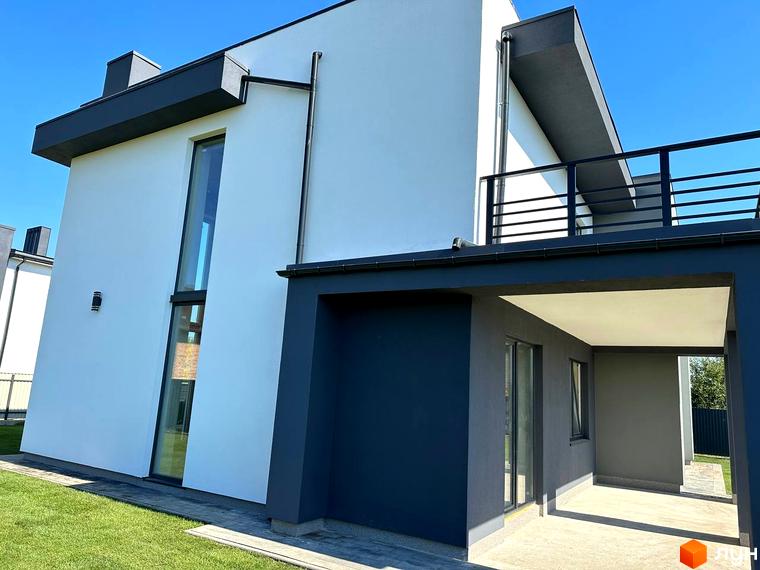 Котеджне містечко КМ PARK by berezivka. Фасад будинку з великим вікном та балконом, зелена прибудинкова територія.