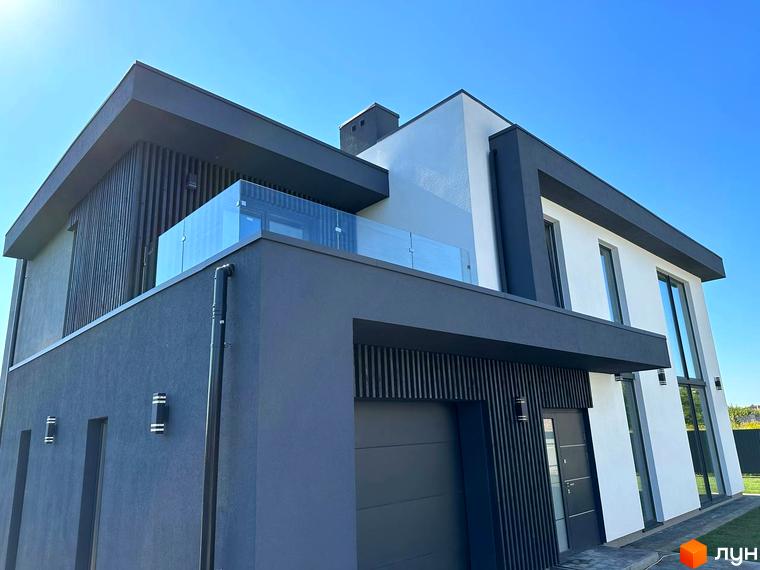 Зовнішній вигляд будинку в КМ PARK by berezivka з скляним балконом та великими вікнами. Навколо будинку доглянута прибудинкова територія з зеленою травою.