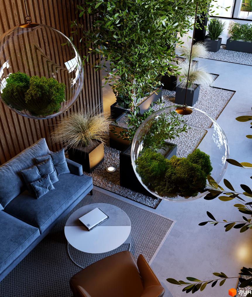 Інтер'єр ЖК BORGO VERDE з рослинами та скляними кулями з рослинами. Сірий диван, кавовий столик та крісло. Навколо зелень та каміння.