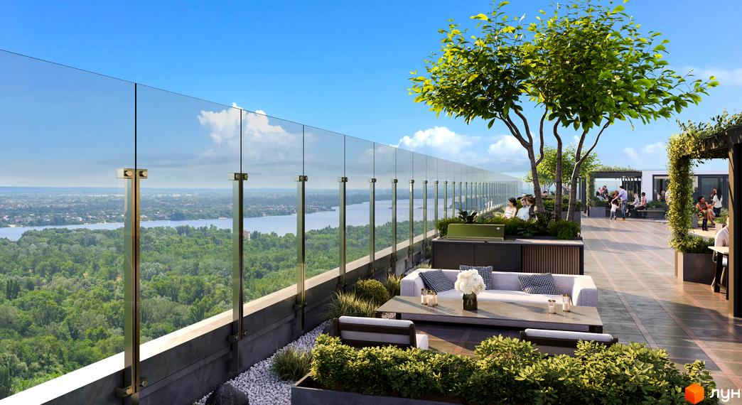 Житловий комплекс Central Hills з терасою на даху та зоною відпочинку з диваном і столом. Навколо зелені дерева та вид на річку.