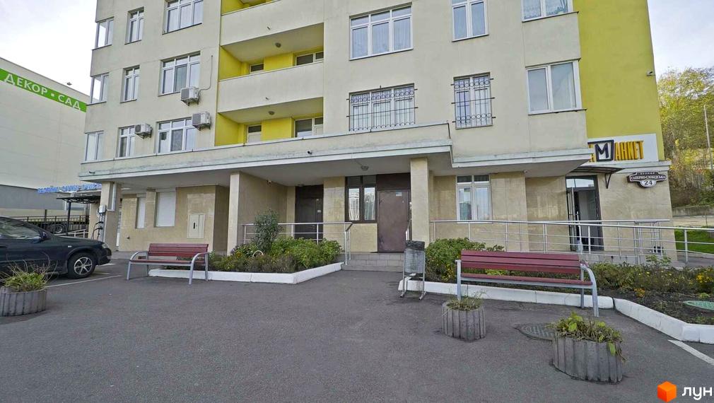 Житловий комплекс на вул. Саперно-Слобідська, 24. Вид на фасад будинку з прибудинковою територією та парковкою.