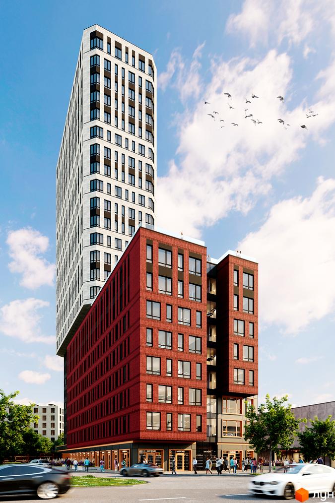 Багатоповерховий будинок БФК Industrial з червоної цегли та білим фасадом, з магазинами на першому поверсі. На фоні блакитне небо з хмарами.