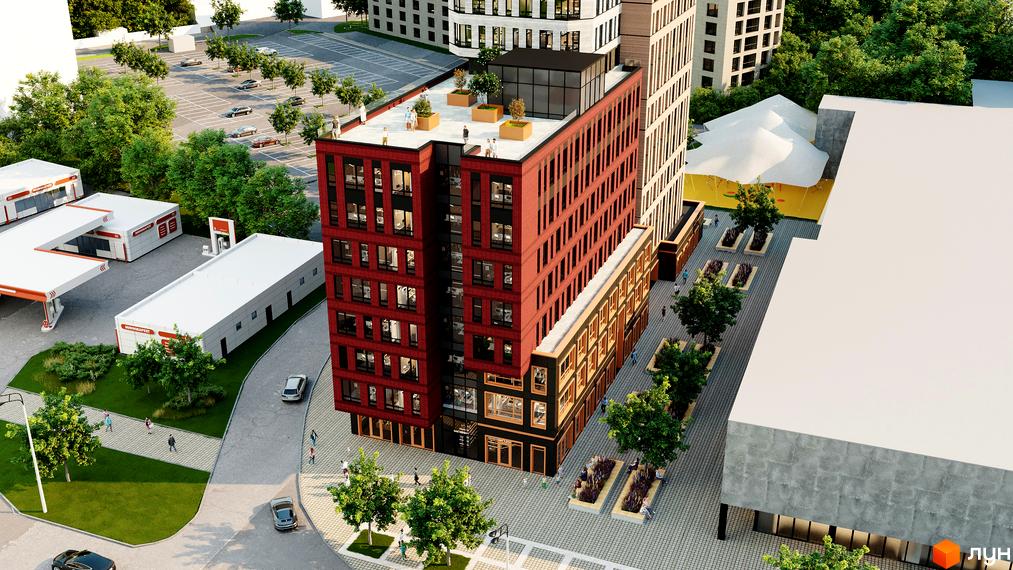 Висотна будівля з червоної цегли в ЖК Industrial, поруч з якою розташовані дерева, парковка та АЗС.