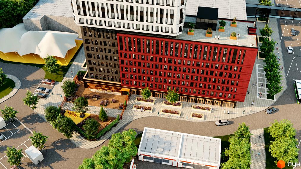 Висотна будівля БФК Industrial з червоною цегляною фасадною частиною та прибудинковою територією з озелененням, парковкою та дитячим майданчиком.