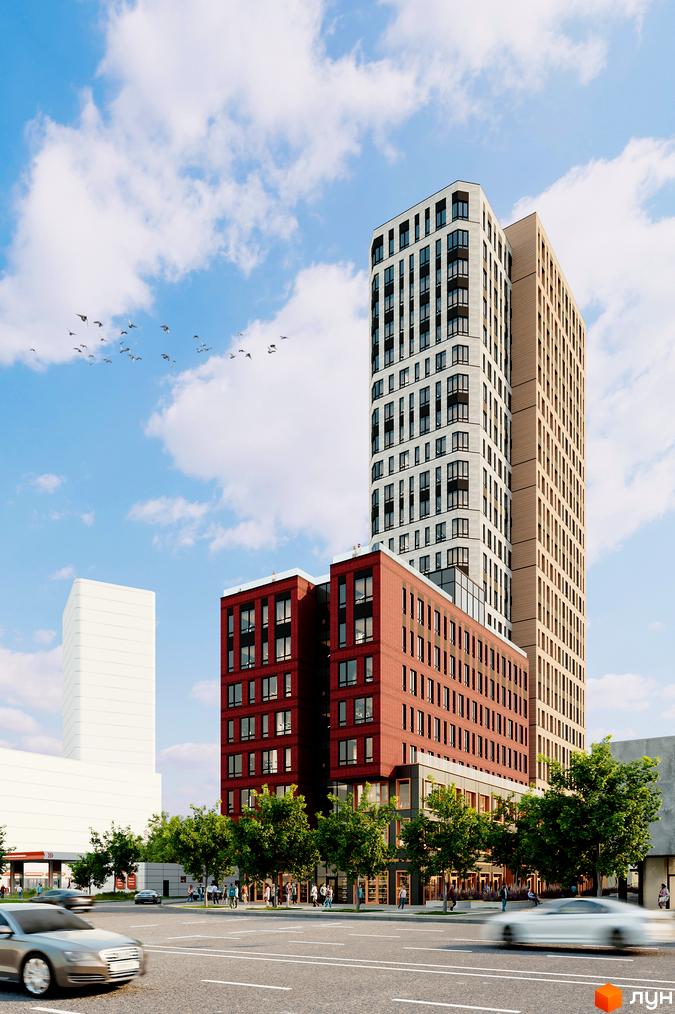 Багатоповерховий будинок ЖК Industrial з фасадами з цегли та світлого каменю. Навколо будівлі зелені дерева та проїжджа частина з автомобілями.