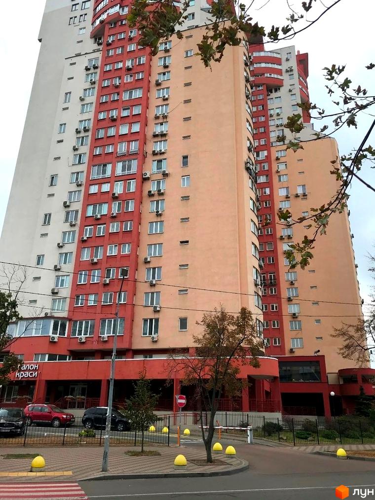 Житловий комплекс на вул. Тичини, 18б. Будинок з червоно-жовтою фасадною обробкою та прибудинковою територією.