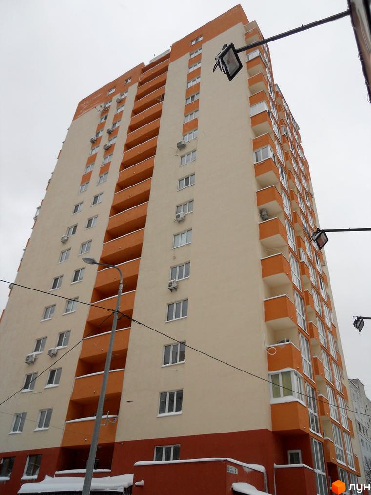 Зовнішній вигляд багатоповерхового будинку в Житловому комплексі Мінський. Високий будинок з балконами та кондиціонерами.