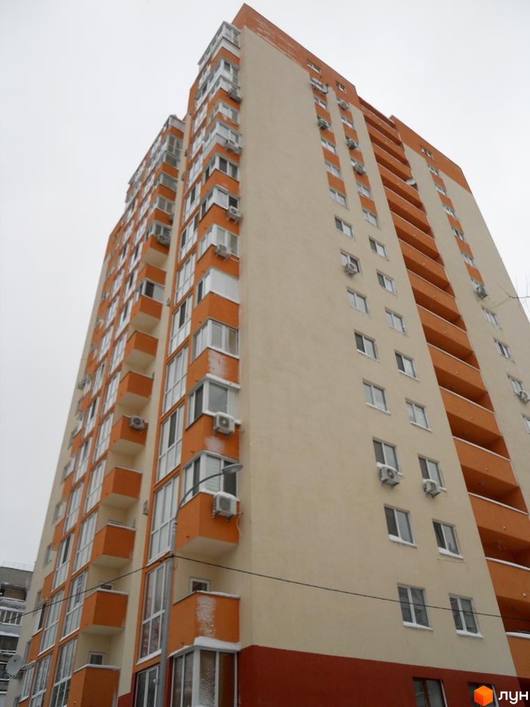 Зображення багатоповерхового будинку Житлового комплексу Мінський. Вигляд фасаду з вікнами та балконами.
