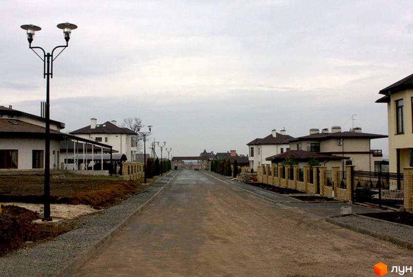 Зображення вулиці в Котеджному містечку Флоринка з будинками обабіч. Вигляд на дорогу та прибудинкові ділянки.