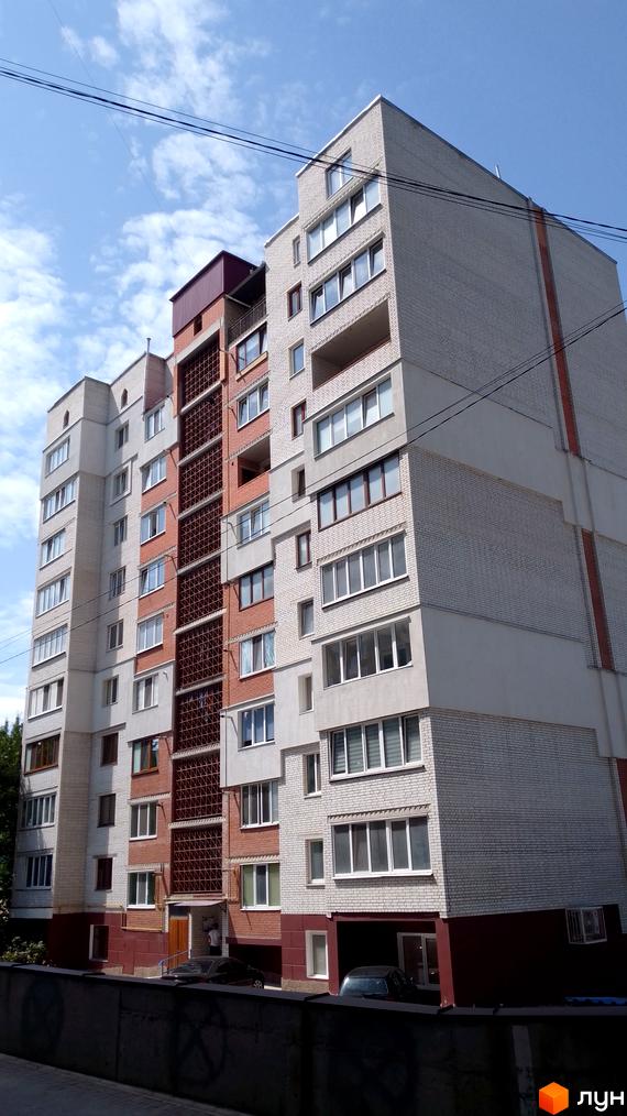 Багатоповерховий житловий комплекс на вулиці 15 Квітня, 2д, з цегляним фасадом та балконами. Навколо будинку видно прибудинкову територію з деревами та припаркованими автомобілями.