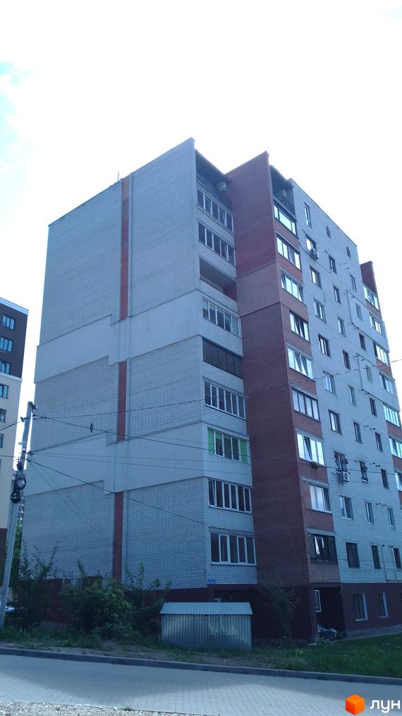 Багатоповерховий житловий комплекс на вулиці 15 Квітня, 2д, із цегляним фасадом та балконами. Навколо будинку зелені насадження та дорога.