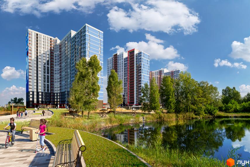 Житловий комплекс Причал 8 з високими будинками та блакитними вікнами, що відображають небо. На прибудинковій території розташовані зелені зони, озеро та дитячі майданчики.