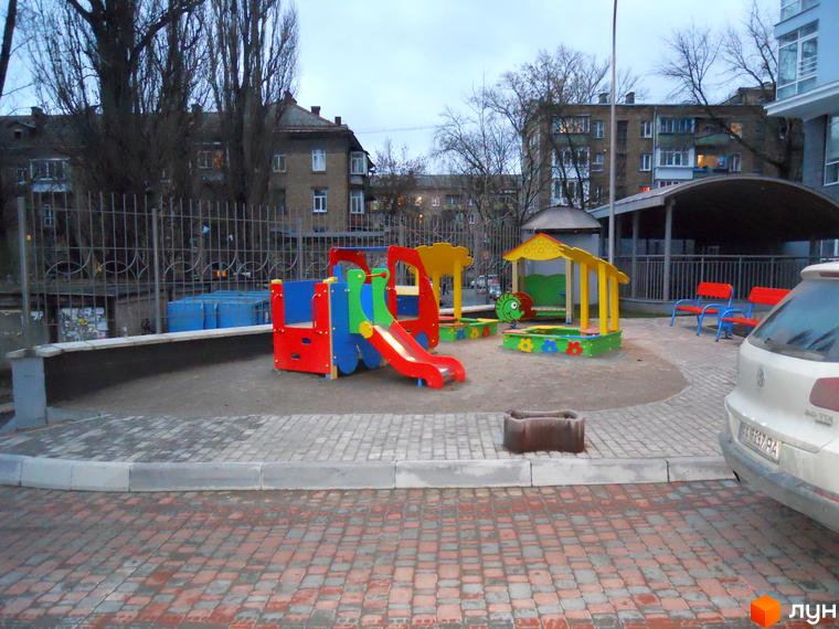 Дитячий майданчик з гіркою та пісочницею на прибудинковій території житлового комплексу Срібна Вежа.