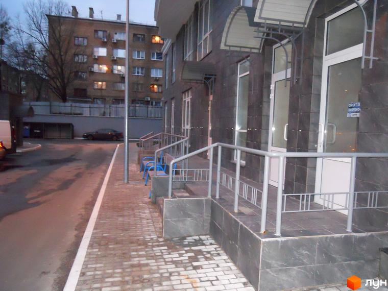 Житловий комплекс Срібна Вежа, фасад будинку з входами та прибудинковою територією, освітлення в вечірній час.