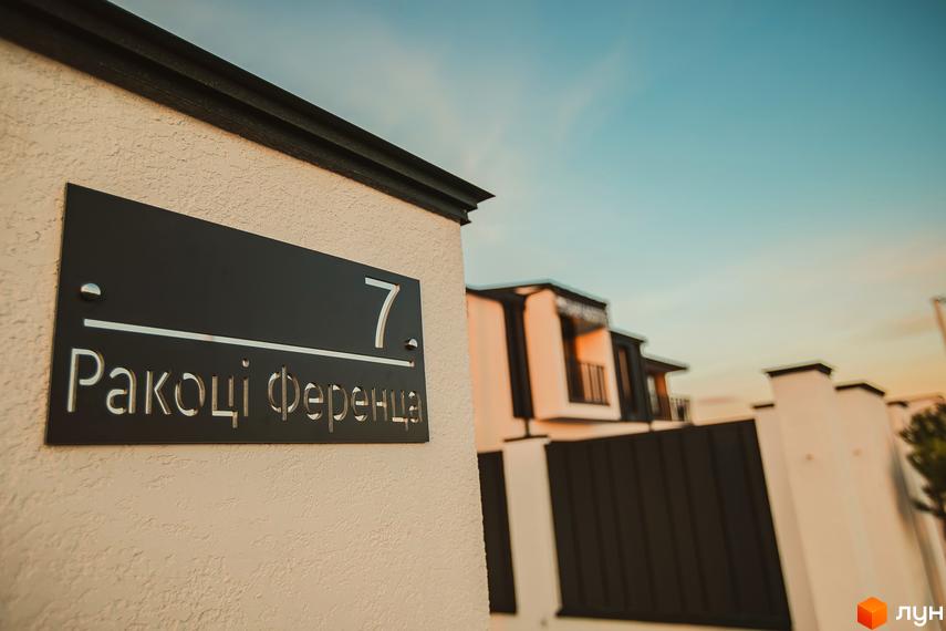 Таунхауси Modern House: фасад будинку з номером 7 та назвою вулиці Ракоці Ференца. Навколо новобудови огороджена територія та паркан.