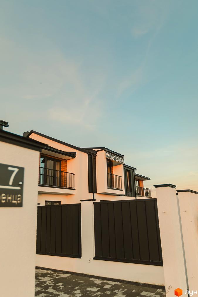 Зовнішній вигляд таунхаусів Modern House з балконами та парканом. На фасаді видно номер будинку 7 та телефон.