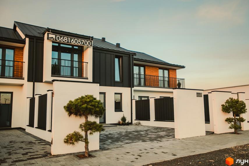 Зовнішній вигляд таунхаусів Modern House з чорними та дерев'яними фасадами, балконами та білими стінами. Перед будинками розташований двір з бруківкою та зеленими насадженнями.