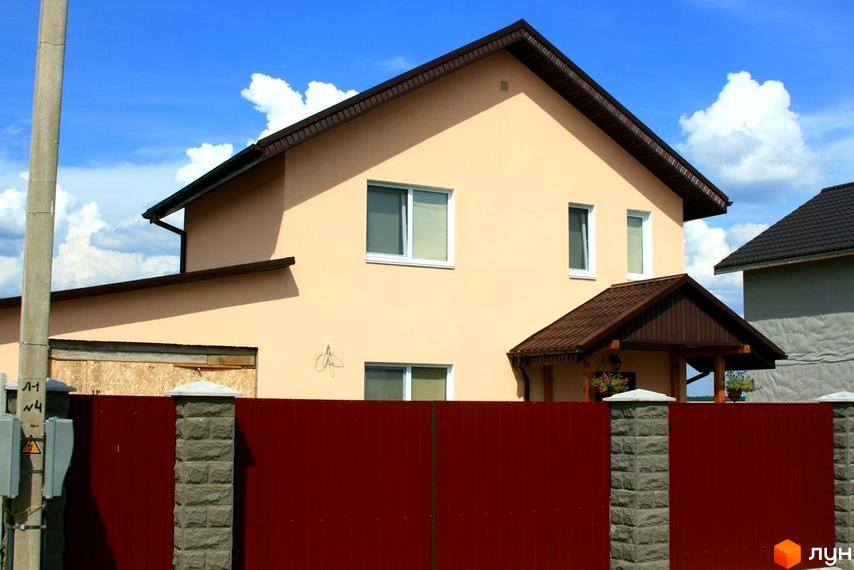 Зображення будинку в Котеджному містечку Солнечная Поляна. Двоповерховий будинок з коричневим дахом та червоним парканом.