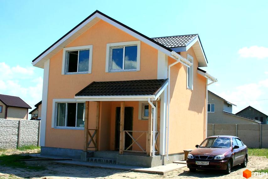 Фото двоповерхового будинку в Котеджному містечку Солнечная Поляна. На передньому плані видно автомобіль та прибудинкову територію.