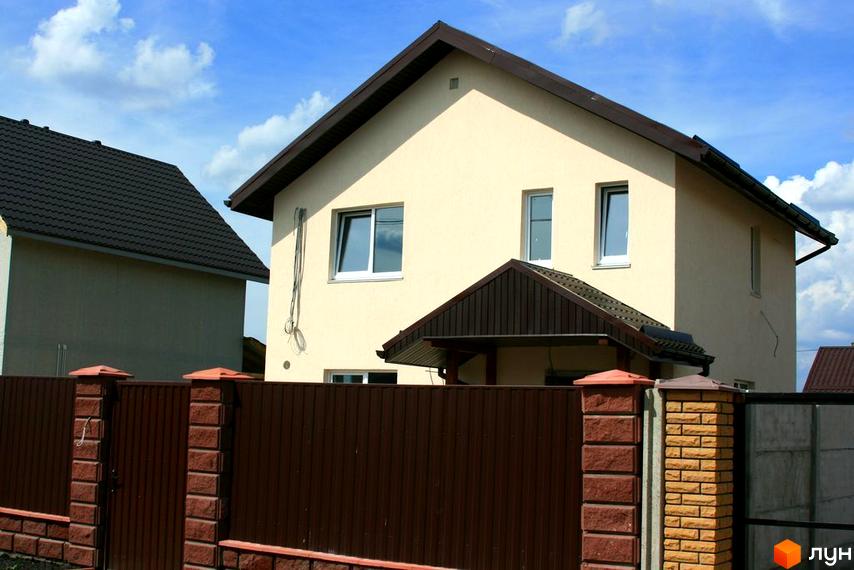 Зображення двоповерхового будинку в Котеджному містечку Солнечная Поляна. Вигляд фасаду будинку та частини огорожі.