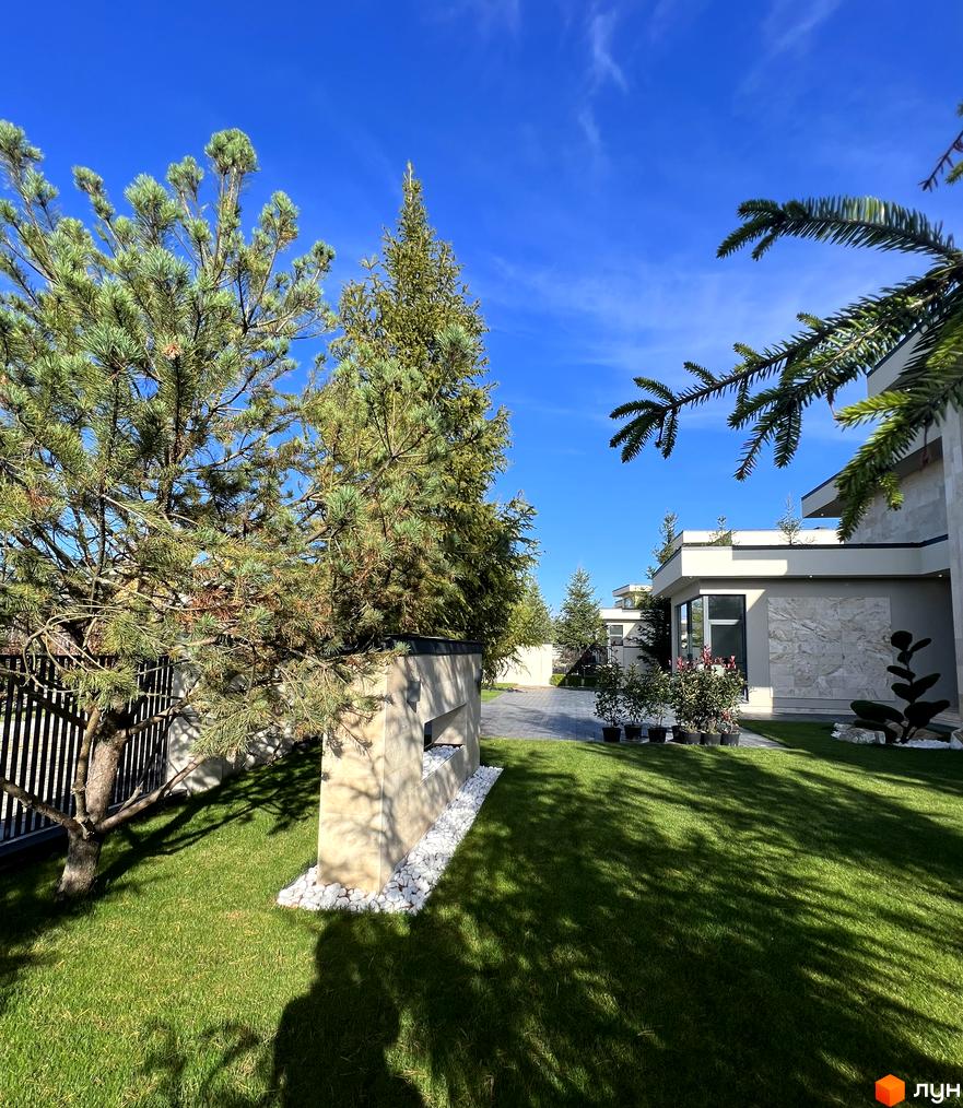 Зовнішній вигляд будинку в Котеджному містечку Riviera City Park з доглянутою прибудинковою територією та зеленим газоном.