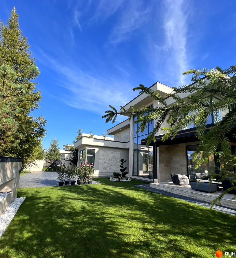 Котеджне містечко КМ Riviera City Park: двоповерхові будинки з панорамними вікнами та доглянутим газоном. Прибудинкова територія з деревами та квітами.