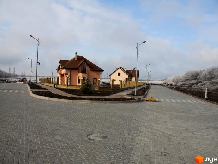 Фото Котеджного містечка Європа: двоповерхові будинки з коричневими дахами та світлими стінами. Навколо будинків облаштована прибудинкова територія.