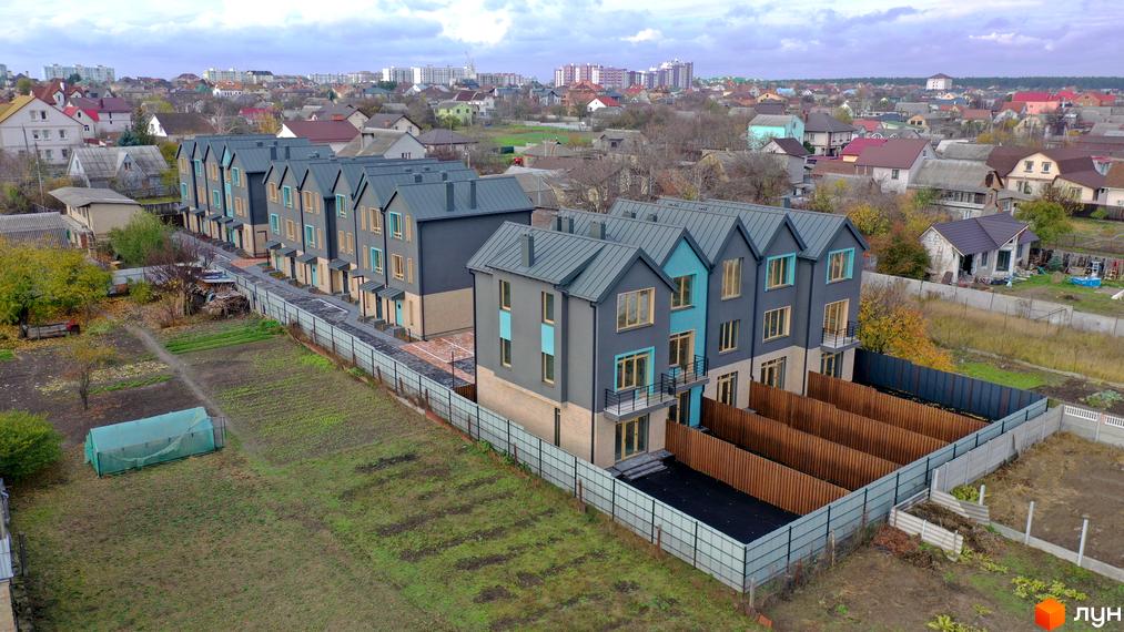 Таунхауси New Smart 13 – це двоповерхові будинки сірого кольору з бірюзовими вставками та пласким дахом. На території комплексу є зелені насадження та паркомісця.